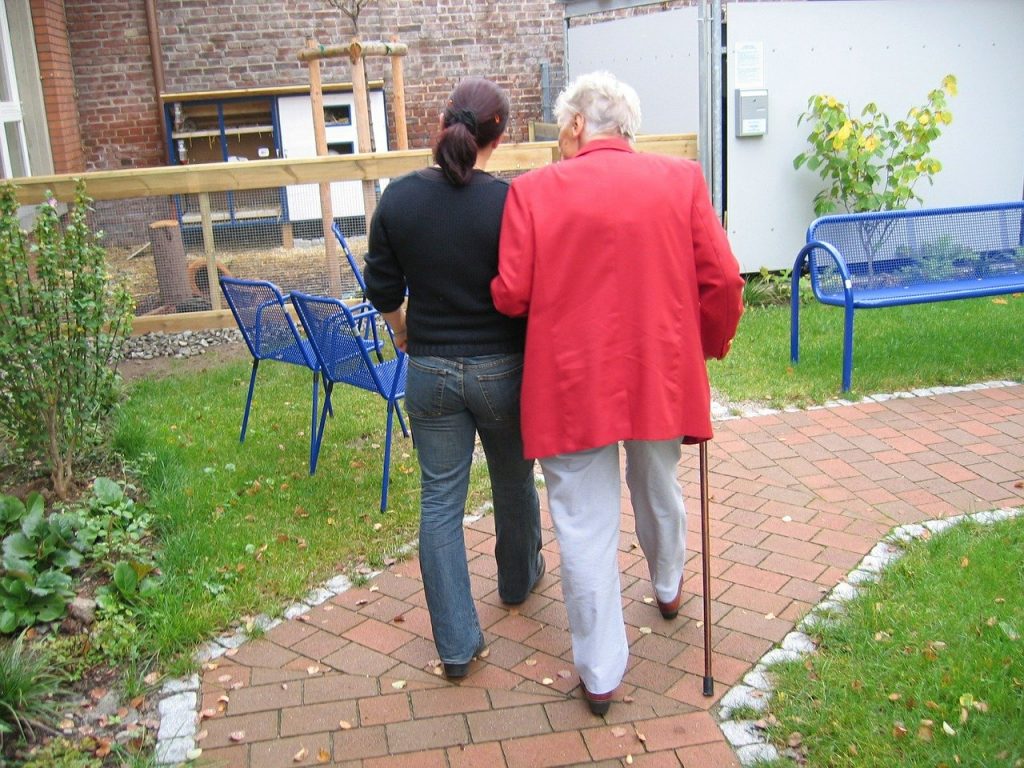 Personne âgée en promenade avec un soignant